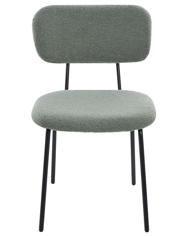 Light green bouclé dining chair without armrests, with a softly curved upholstered backrest and padded seat, on slim black metal legs.