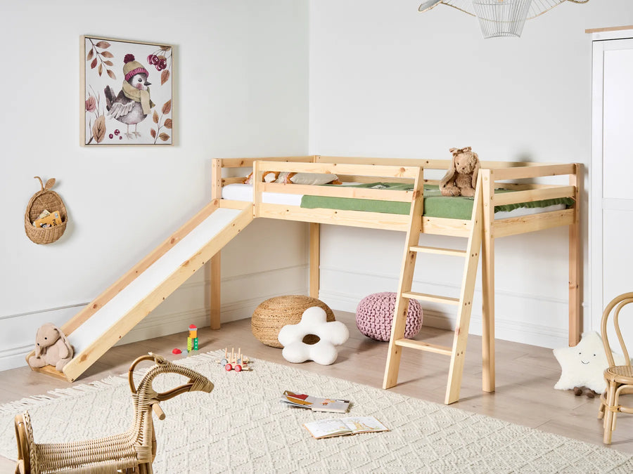 Children's room with a wooden loft bed with slide, toys, and decor.