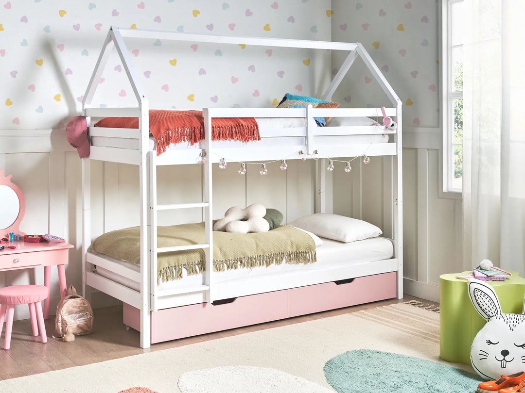 Children's room with a white house-shaped bed, pink drawers, and colorful decor.