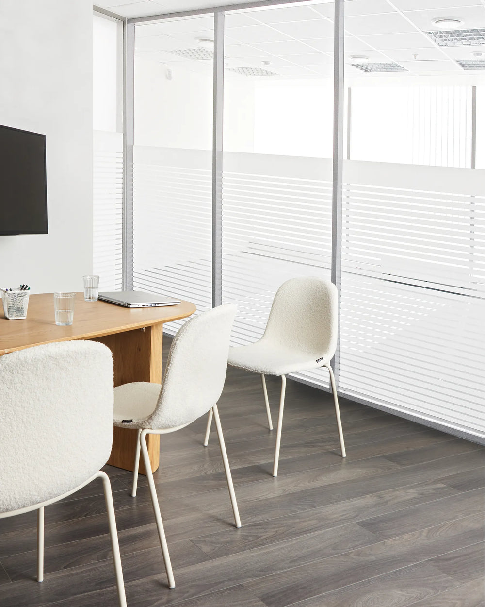 Modern office-style meeting space featuring soft bouclé chairs that add comfort and a clean, contemporary look.
