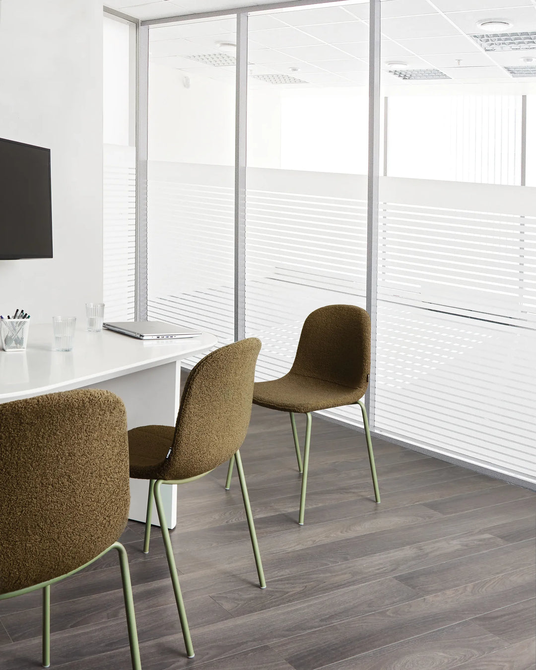 Contemporary meeting space featuring textured bouclé chairs that bring warmth, comfort, and a modern organic feel.