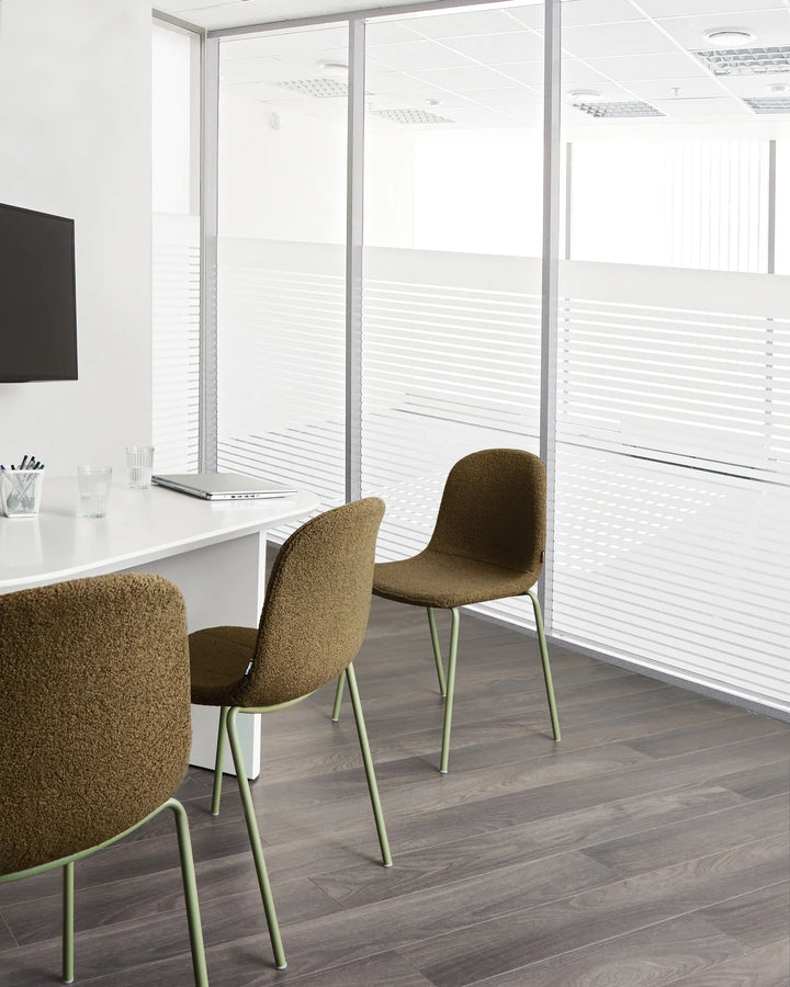 Contemporary meeting space featuring textured bouclé chairs that bring warmth, comfort, and a modern organic feel.