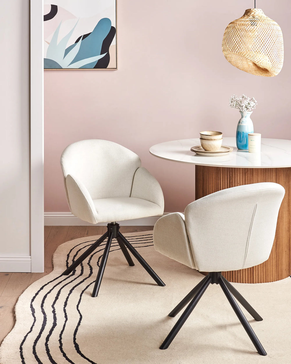 Off-white fabric swivel dining chairs with black metal bases around a dining table in a bright, modern dining space with minimalist décor.