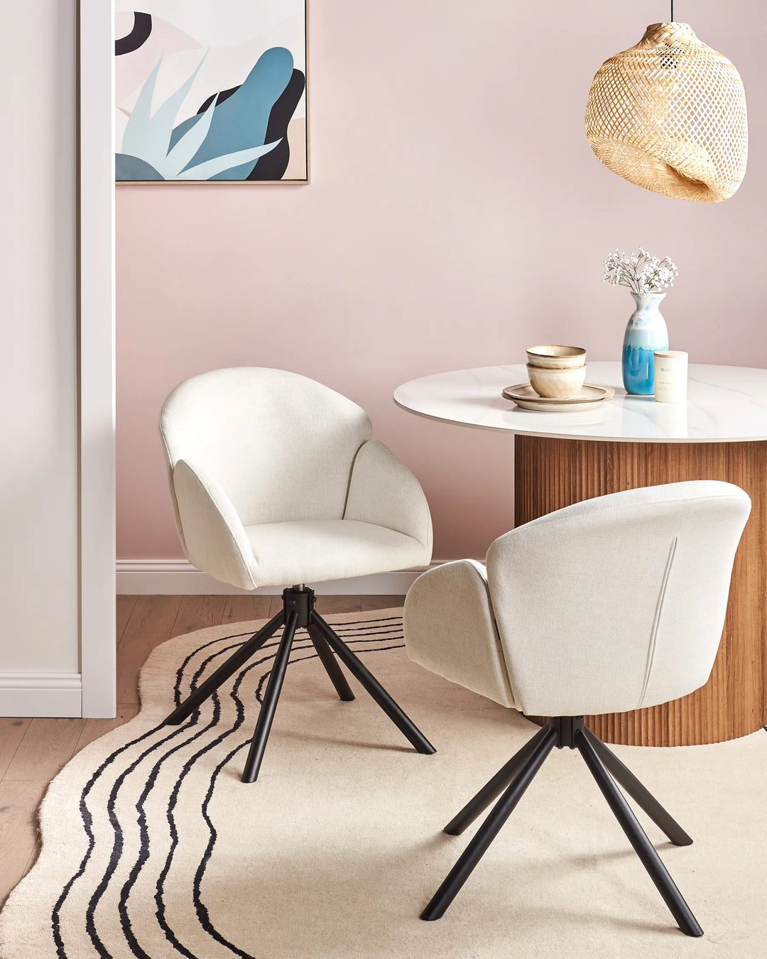 Off-white fabric swivel dining chairs with black metal bases around a dining table in a bright, modern dining space with minimalist décor.