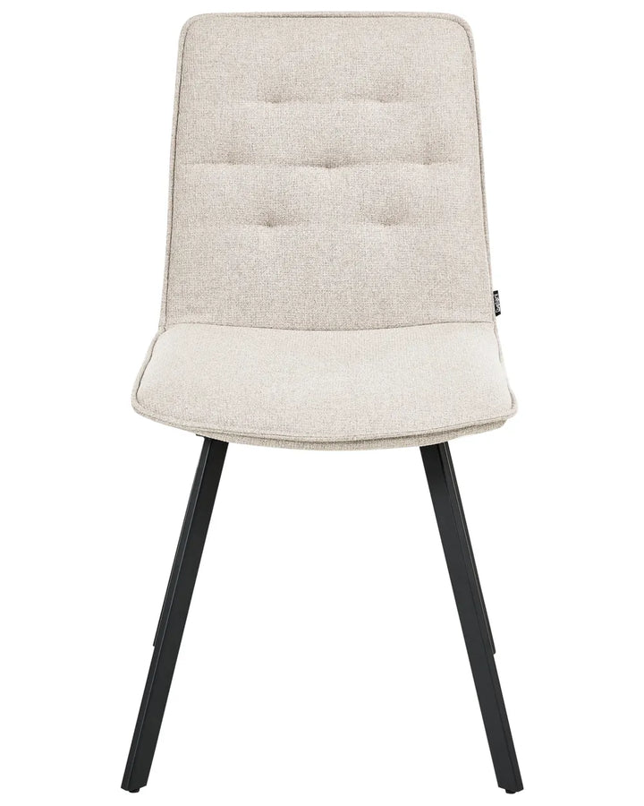 Light beige upholstered dining chair with subtle tufted detailing and black metal legs.