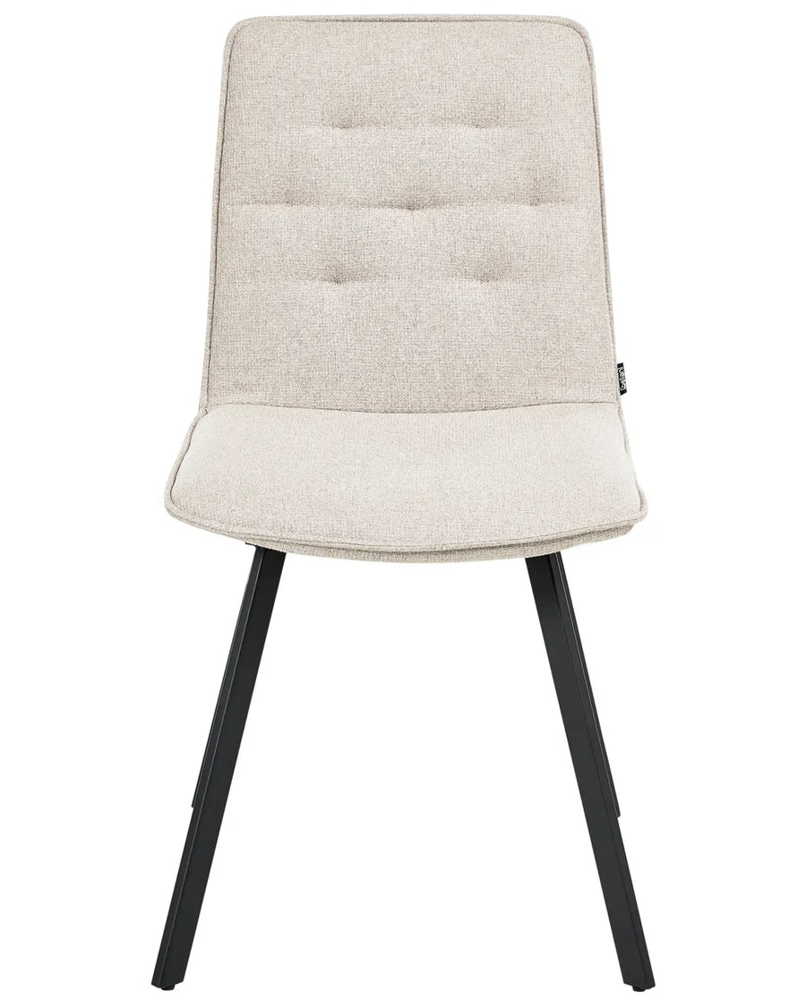 Light beige upholstered dining chair with subtle tufted detailing and black metal legs.