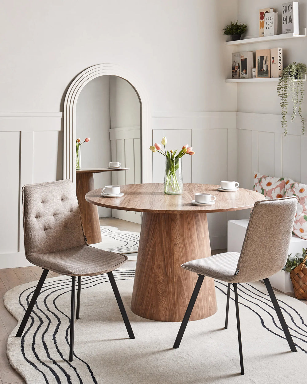Contemporary taupe dining chairs paired with a round wood table, creating a warm and inviting dining setting.
