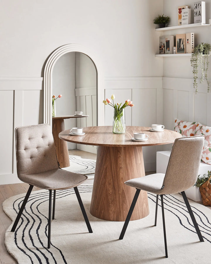Contemporary taupe dining chairs paired with a round wood table, creating a warm and inviting dining setting.