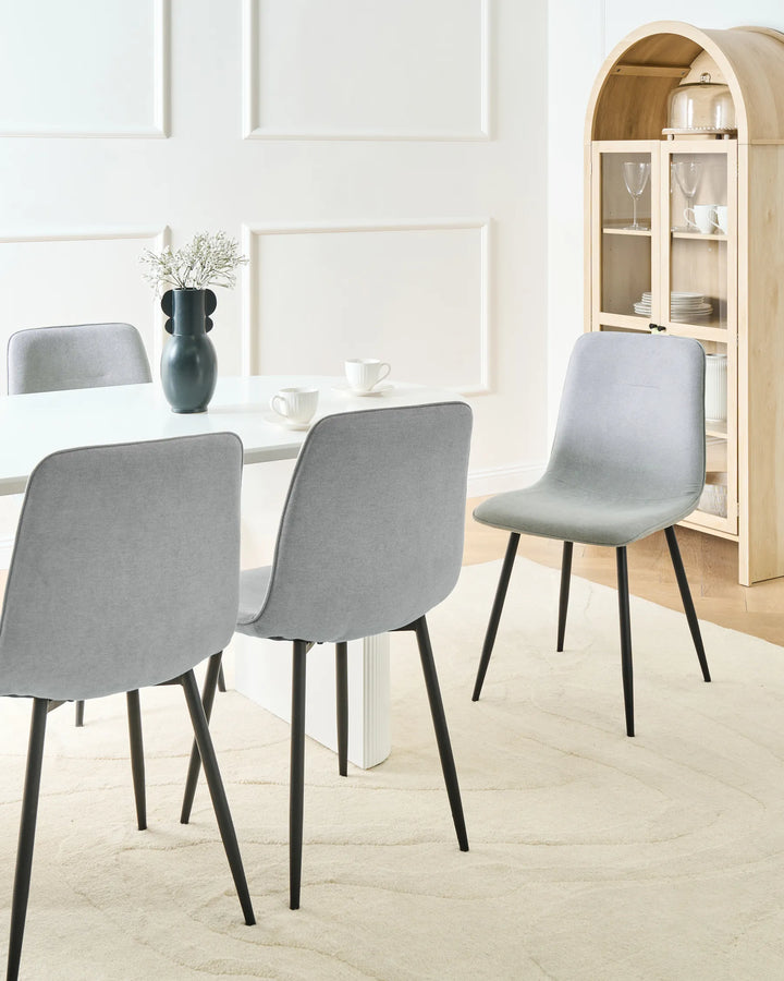 Modern light grey dining chairs styled around a white dining table, bringing a bright, elegant, and contemporary feel to the dining area.