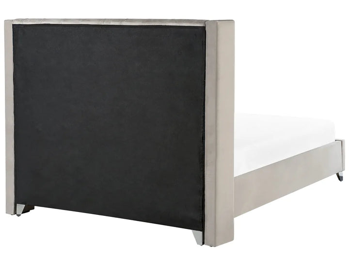 Bed with black upholstered headboard and white mattress on a white background