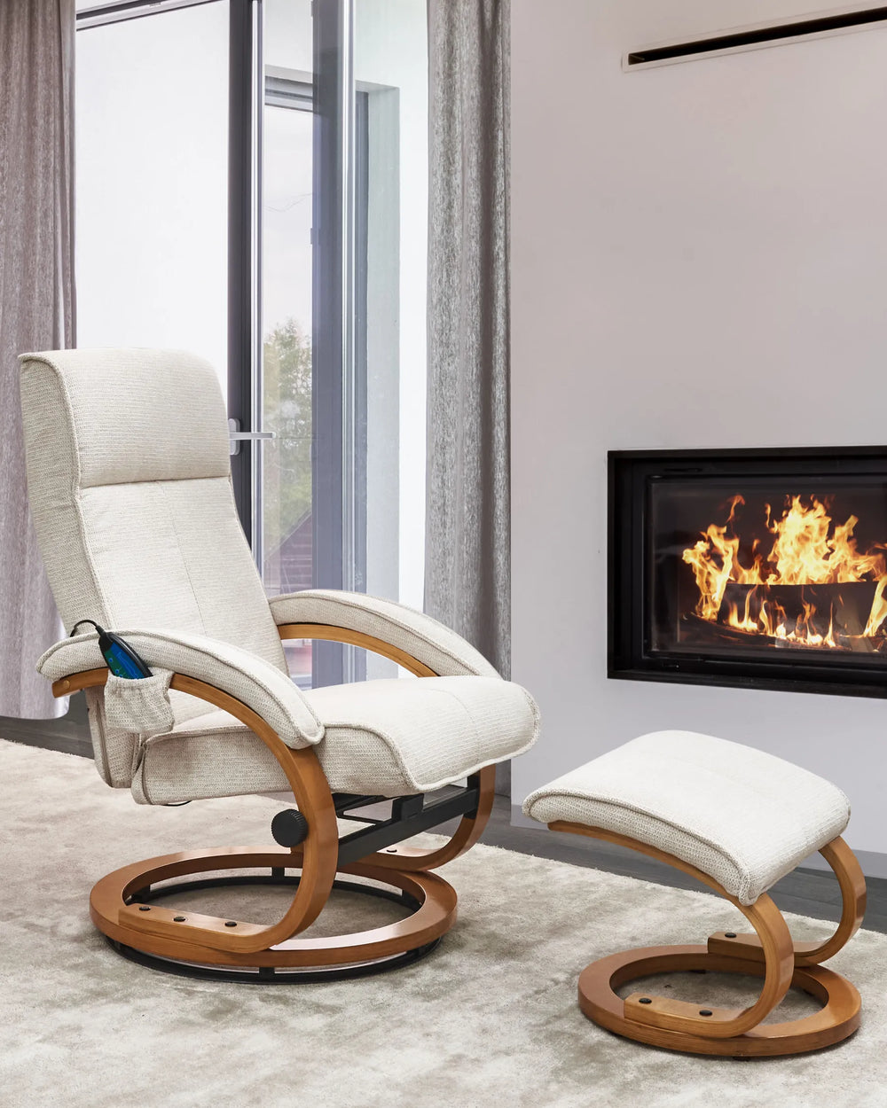White recliner chair with wooden frame and ottoman in front of a fireplace.