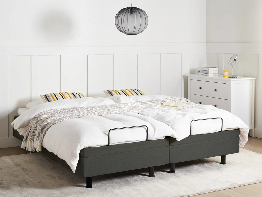 Gray bed frame with white bedding in a minimalistic bedroom.
