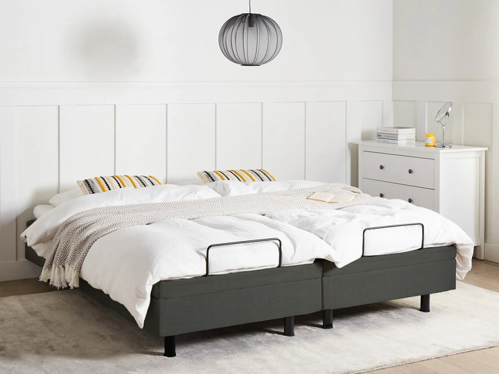 Gray bed frame with white bedding in a minimalistic bedroom.