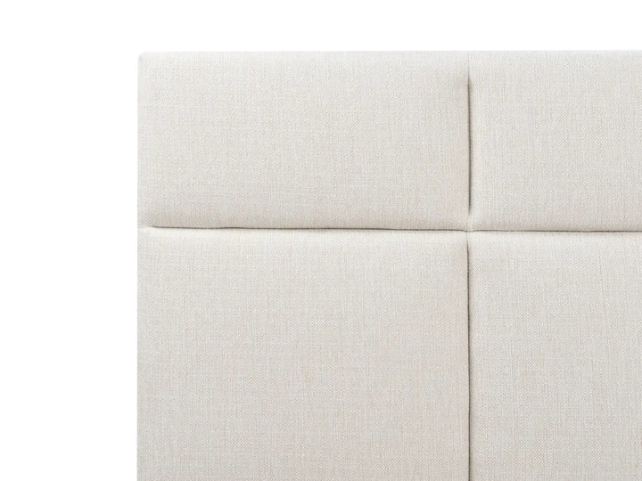 Close-up of a light gray upholstered headboard with a white background