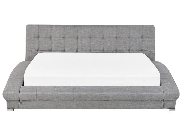 Gray upholstered bed with a white mattress on a white background