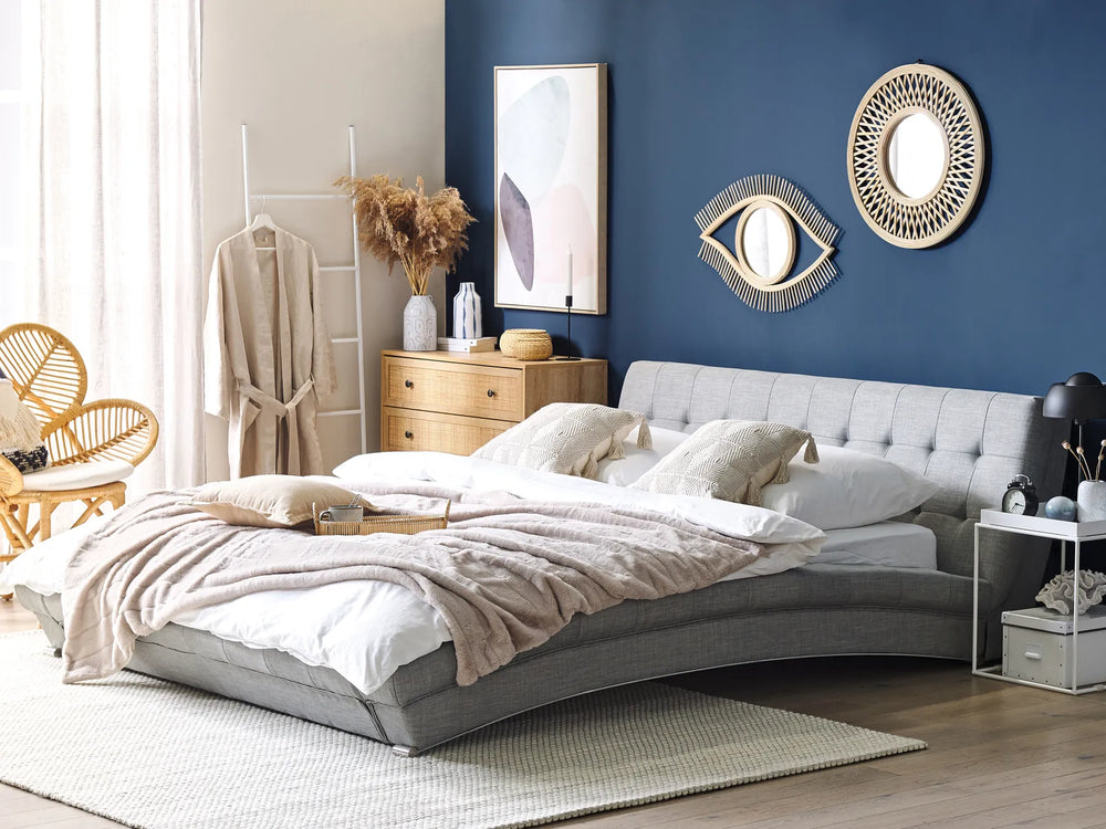 Modern bedroom with a gray upholstered bed, wooden nightstands, and decorative wall art.