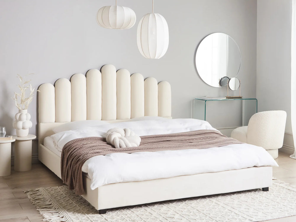 Modern bedroom with a white upholstered bed, matching headboard, and decorative elements.
