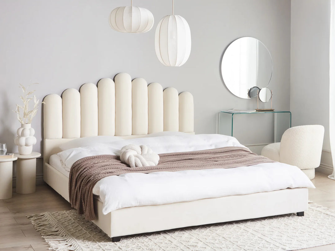 Modern bedroom with a white upholstered bed, matching headboard, and decorative elements.