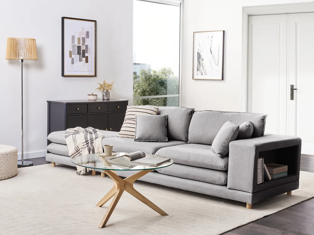 Modern living room with a gray sectional sofa, coffee table, and decorative items.