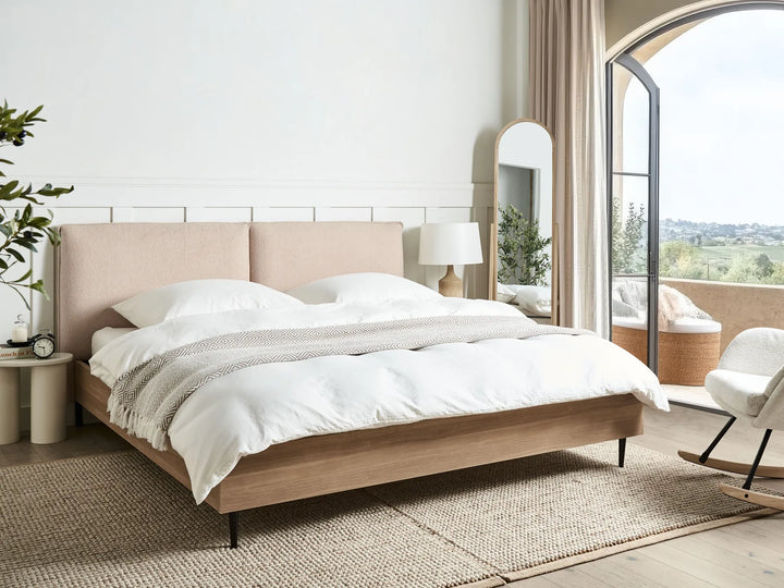 Modern bedroom with a bed, nightstands, and a view of a cityscape.
