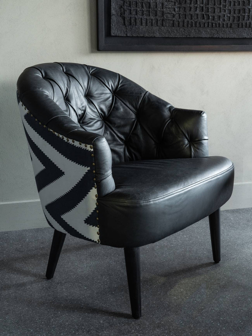 Black leather armchair with patterned backrest in a room setting