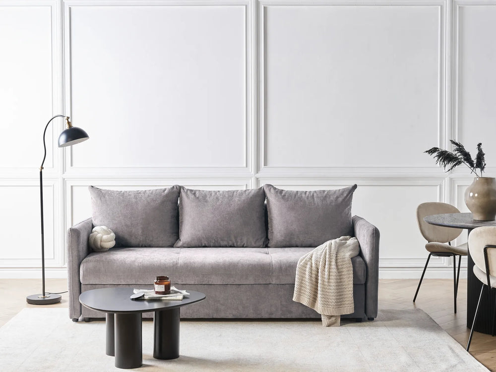 Gray sofa in a modern living room with white walls and minimal decor.