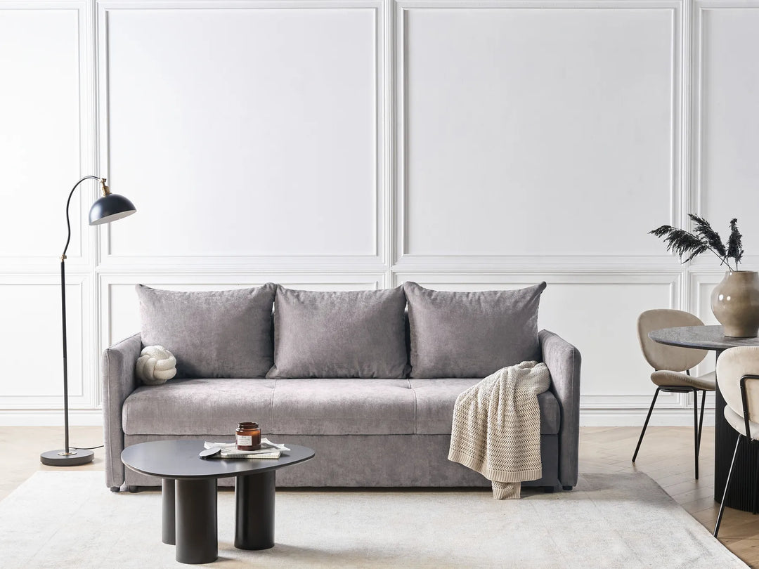 Gray sofa in a modern living room with white walls and minimal decor.