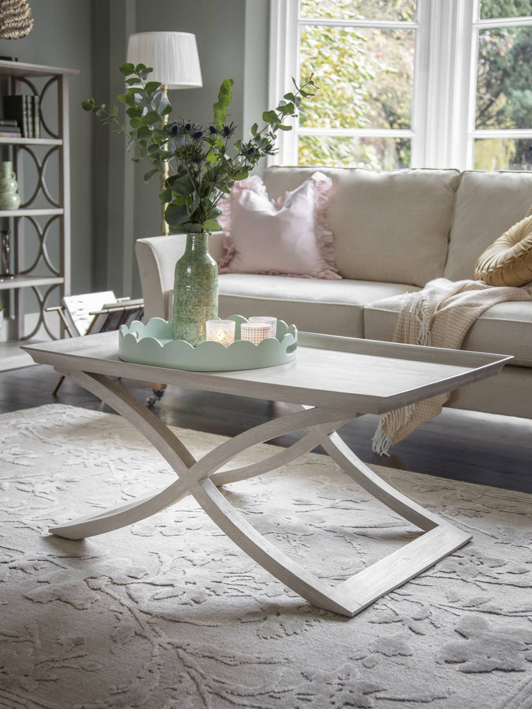 Living room with a white coffee table, beige sofa, and decorative elements.