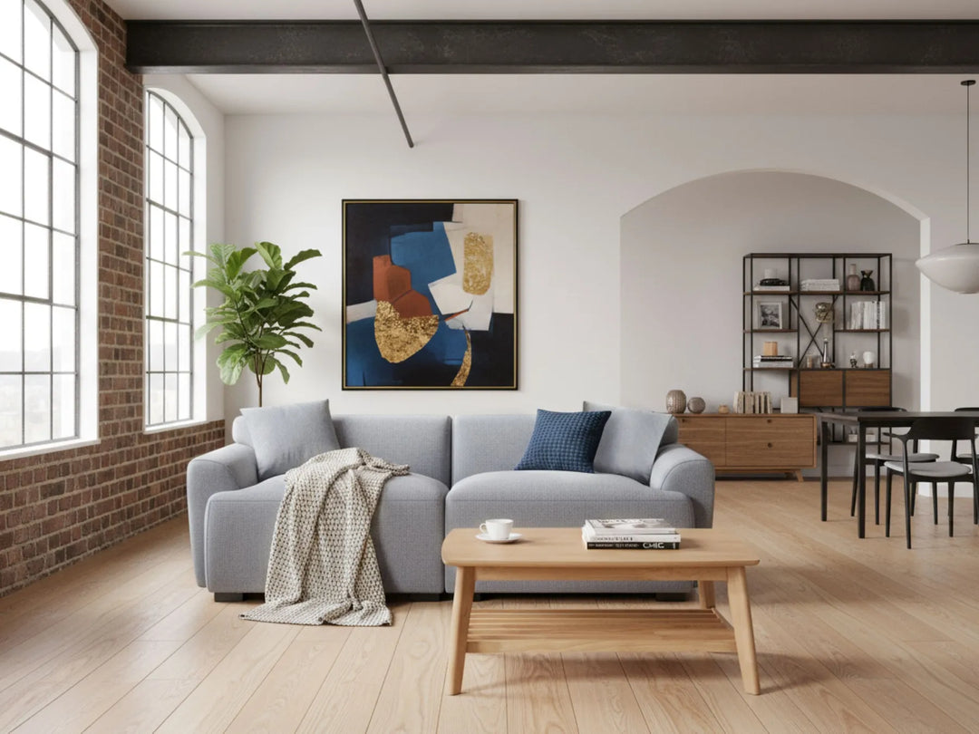 Modern living room with gray sofa, wooden coffee table, and abstract art on the wall.