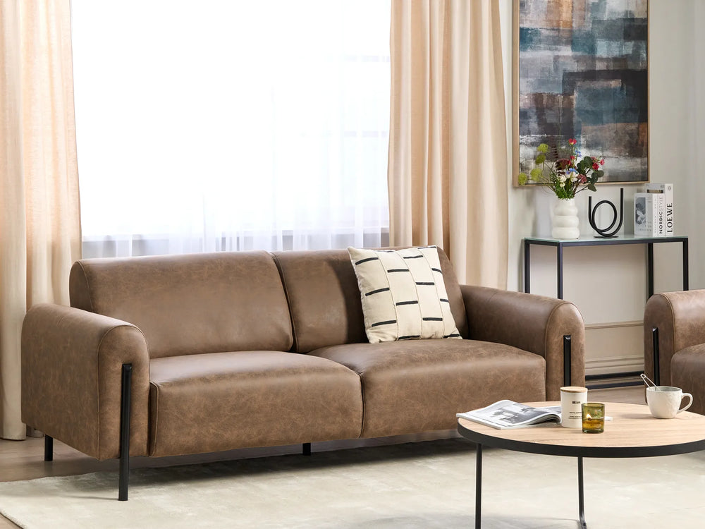 Brown sofa in a living room with a coffee table and decorative items.