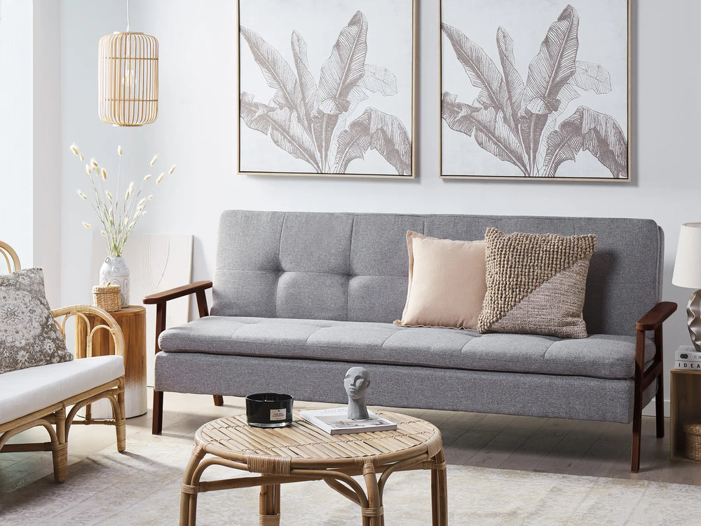 Gray sofa in a living room with decorative pillows and wall art.