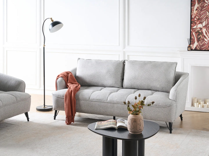 Gray sofa in a living room with a lamp, coffee table, and decorative items.
