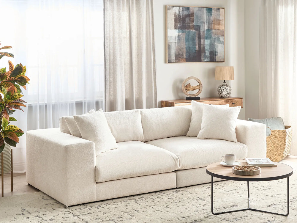 White sofa in a living room with a coffee table and decorative items.