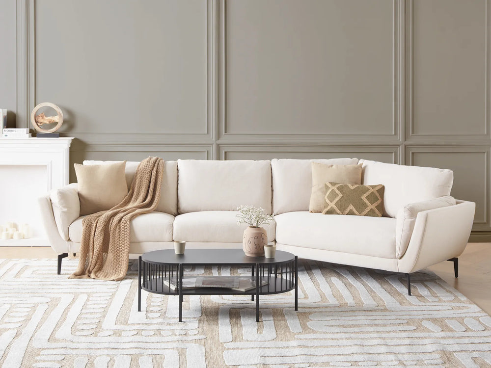 White sectional sofa in a living room with decorative pillows and a coffee table.
