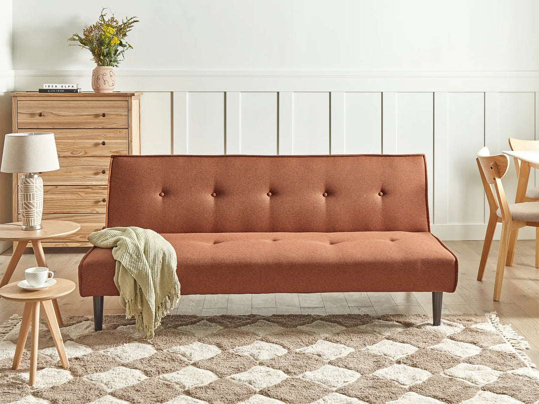 Brown sofa in a living room setting with a wooden cabinet and decorative items.