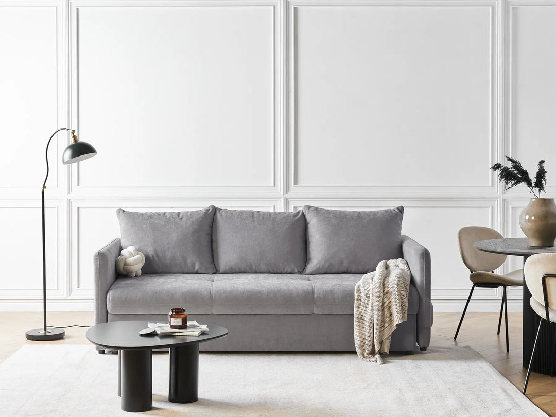Gray sofa in a modern living room with white walls and minimal decor.