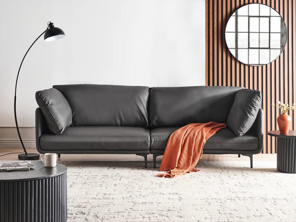 Gray sofa in a modern living room with a lamp and small table.