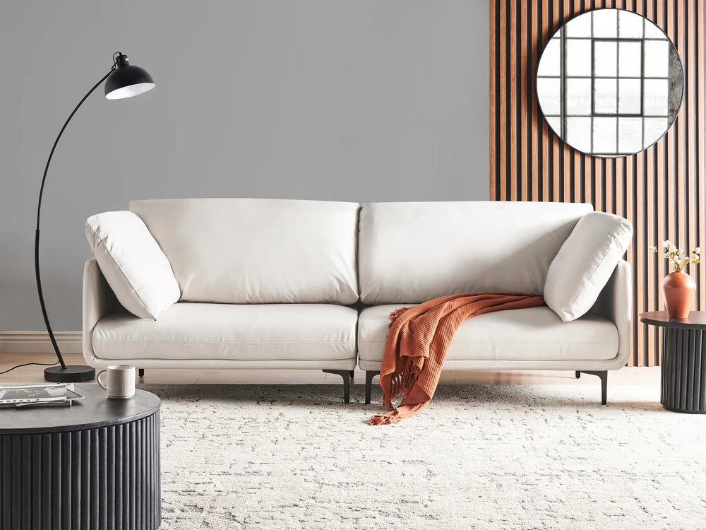 Beige sofa with a red blanket in a modern living room setting.