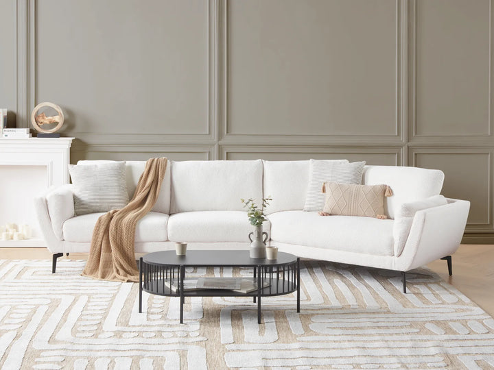 White sectional sofa in a living room with a coffee table and decorative items.