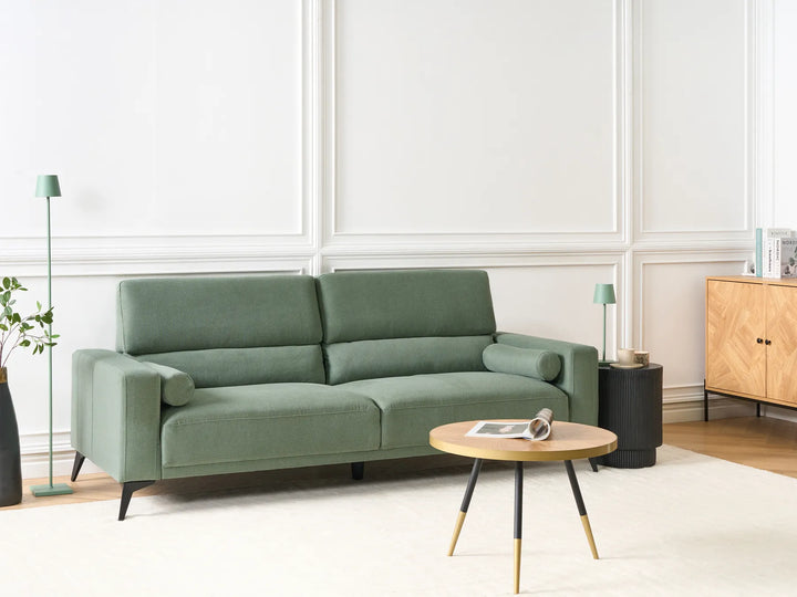 Green sofa in a modern living room with a wooden cabinet and coffee table.