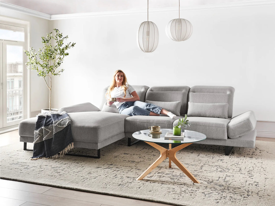 Light grey fabric right-hand corner sofa with adjustable headrest and backrests in a modern living room