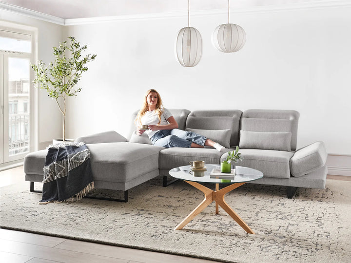 Light grey fabric right-hand corner sofa with adjustable headrest and backrests in a modern living room
