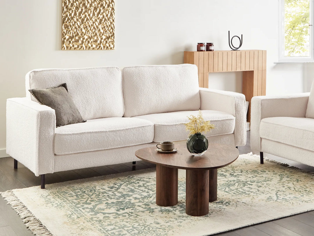 Modern living room with a white sofa, wooden coffee table, and decorative items.