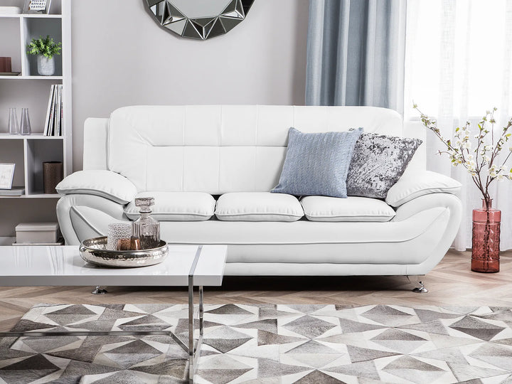 White sofa in a living room with decorative pillows and a coffee table.