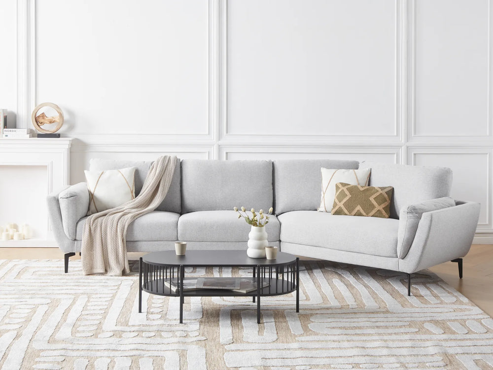 Gray sectional sofa in a living room with a coffee table and decorative items.