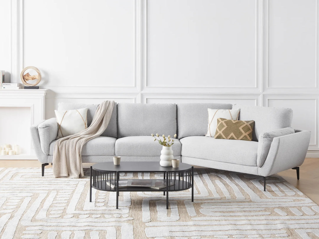 Gray sectional sofa in a living room with a coffee table and decorative items.