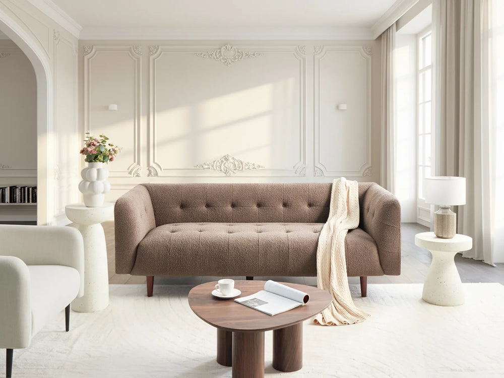 Modern living room with a brown sofa, coffee table, and decorative elements.