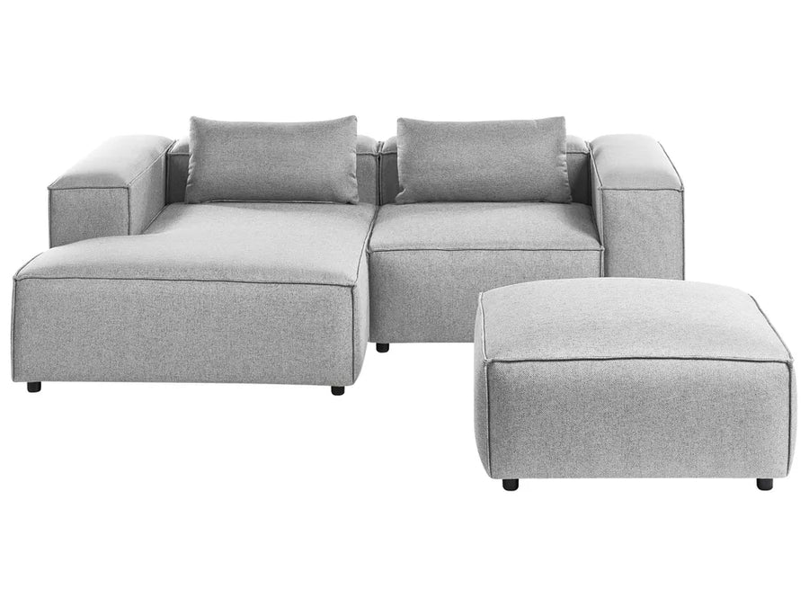 Gray sectional sofa with ottoman on a white background