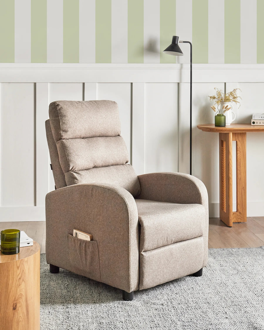 Beige recliner chair in a living room setting with striped wallpaper and wooden furniture.