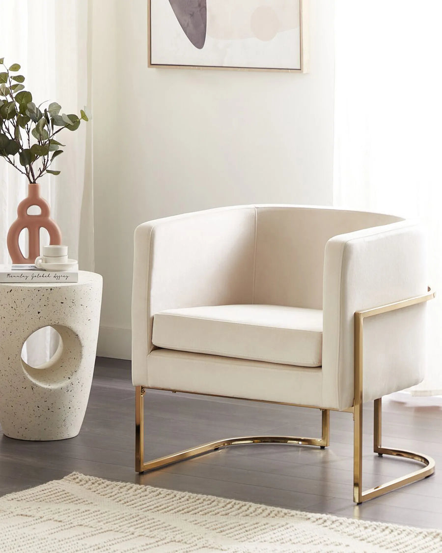 Beige armchair with gold legs in a modern living room setting